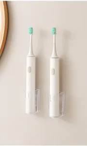 Vista dettagliata di due supporti a parete trasparenti per spazzolini da denti elettrici.