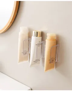 Dettaglio di clip trasparenti a parete per riporre i detergenti per il viso in bagno