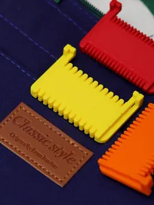 Macro view of colorful plastic hinge locators for handmade sewing on blue textured fabric.