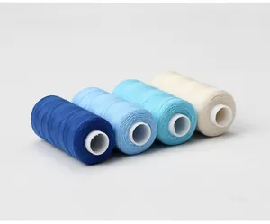 Detailed view showing four durable sewing thread spools in blue and cream white hues.
