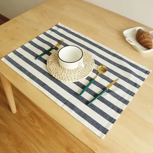 Mantel individual y paño de cocina de algodón a rayas azules y blancas en mesa de madera