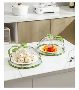 Clear microwave splatter covers protecting steamed buns and peppers on counter.