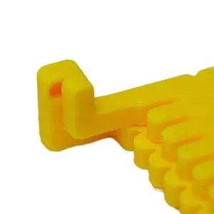 Close-up of yellow plastic sewing hinge positioner and ruler clip tool