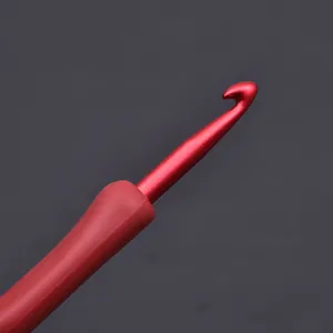 High-quality close-up detail of a red aluminum crochet hook with soft ergonomic TPR handle