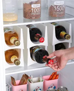 Nahaufnahme von stapelbaren weißen Flaschenregalen aus Kunststoff im Kühlschrank.