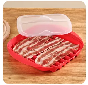 Close-up view of a red microwave bacon cooker tray with a lid and raw bacon slices