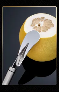 Detail van een rvs pomelo schiller die door de schil van een verse gele vrucht snijdt
