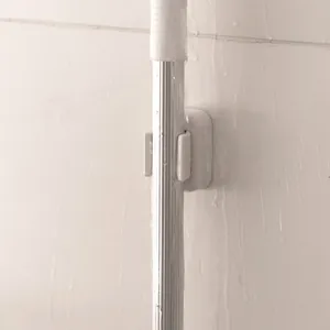 Wall-mounted mop holder with drill-free adhesive design for bathroom organization
