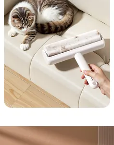 Detailed view of a white lint roller effectively removing cat hair from a cream leather sofa