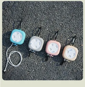 Set of four portable retractable clotheslines with carabiners on a gravel background.