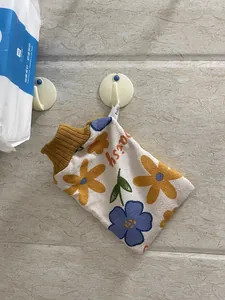 Detailansicht der Textur eines dicken floralen Bade-Peeling-Handschuhs mit Rippbündchen.
