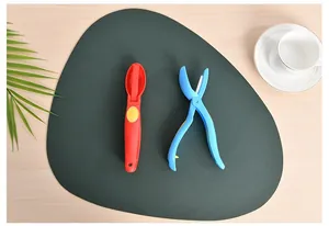 Set dettagliato di schiaccia castagne in plastica rosso e blu su tovaglietta verde