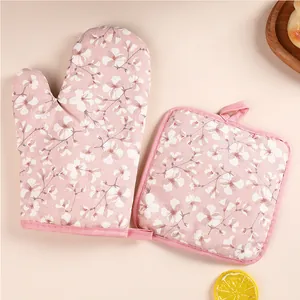 Pink floral oven mitt and pot holder set for kitchen baking and heat resistance.
