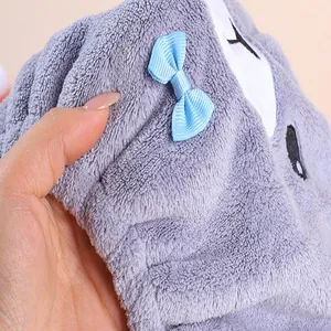 Macro detail of soft grey plush hair drying towel cap featuring a cute blue bow.