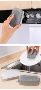 Detailed view of dual-sided sponge scrubbing an appliance and washing a white plate