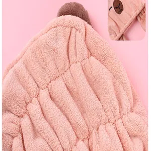 Detail view of pink coral fleece hair drying towel with soft texture and elastic band