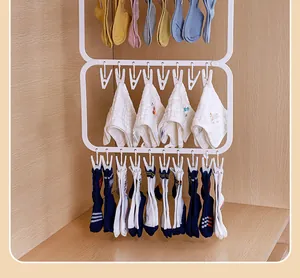 Multi-tier white hanging drying rack with clips for socks and towels in a closet