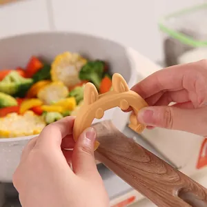 Rabbit shaped silicone spatula holder for pot lids, prevents spills and heat burns.