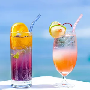 Pailles en verre coloré courbées écologiques pour cocktails dans un décor de plage
