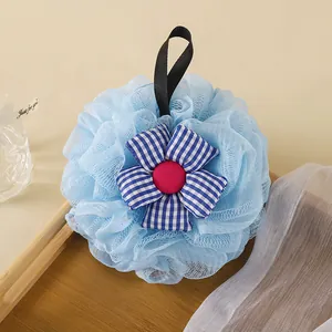 Close-up detail of soft blue bath sponge featuring a checkered sunflower decoration.