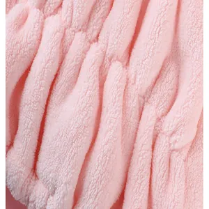 Macro view showing the soft and absorbent coral fleece texture of a pink hair drying cap