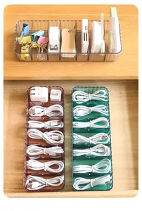 Macro view of clear plastic compartment organizers storing USB cables and office supplies