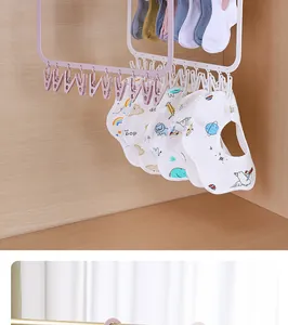 Detail view of a foldable laundry drying rack with multi-clips holding baby bibs and socks.