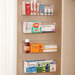 Clear wall-mounted storage organizers for medicine and small items on wooden background