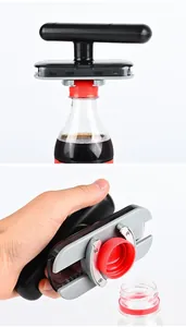 Detailed view of the ergonomic jar opener efficiently twisting off a red plastic bottle cap