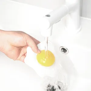 Creatieve siliconen gootsteenzeef in de vorm van een spiegelei onder stromend water