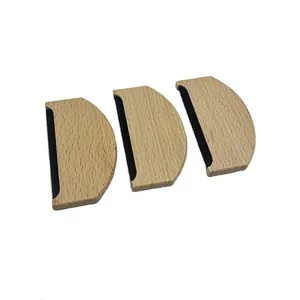 Vista detallada de tres quitapelusas manuales de madera semicirculares para el cuidado textil