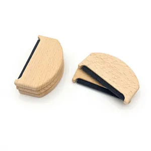 Detalle del quitapelusas manual de madera con malla metálica para el cuidado de prendas de vestir