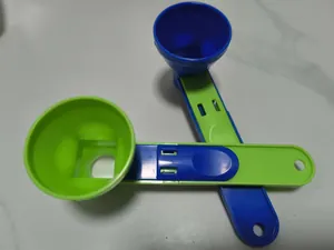 Vista detallada de cucharas de embudo deslizantes de plástico verde y azul para proteínas