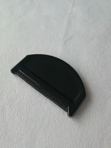 Primer plano de un quitapelusas manual para ropa con mango de plástico negro y red