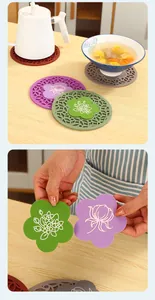 Detail view of silicone heat resistant mats with removable flower-shaped inserts for kitchen use.
