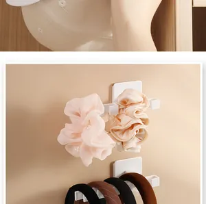 Close-up of white L-shaped wall rack organizing pink scrunchies and hair bands