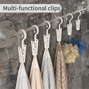 Pinzas para ropa multiusos de plástico blanco con ganchos colgados de una barra.
