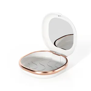 Custodia portatile bianca per apparecchi dentali con specchio e bordo in oro rosa.