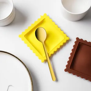 Dettaglio dall'alto di poggia cucchiai in silicone a forma di biscotto colorati