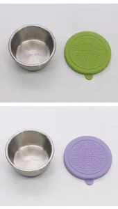 Set of two stainless steel dipping sauce cups with green and purple patterned silicone lids.