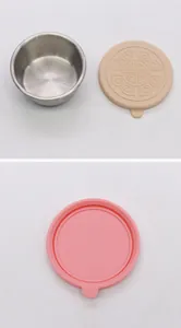 Detail view of stainless steel condiment container with pink and beige silicone lids