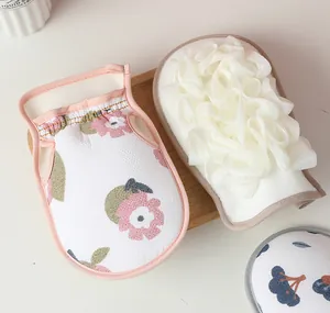 Detailed view showing floral printed exfoliating glove and plush white mesh bath sponge