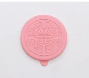 Detailed top view of pink silicone lid with embossed pattern for sauce containers