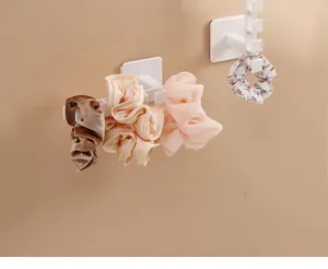 Close-up detail of a white wall-mounted L-shaped storage rack organizing colorful hair scrunchies