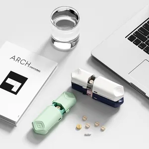 Portable sliding telescopic pill cutter and splitter tool on a clean white minimalist desk