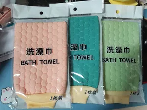 Détail de trois serviettes de bain exfoliantes colorées en emballage individuel