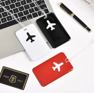 Customizable PVC airplane luggage tags in black white and red colors on a laptop keyboard