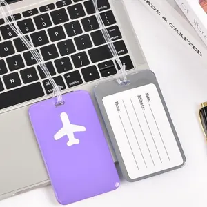 Purple and grey PVC airplane luggage tags set against a laptop background