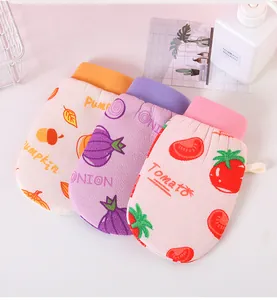 Close-up of three colorful exfoliating bath gloves with pumpkin, onion, and tomato prints