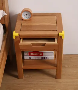 Yellow L-shaped corner protectors installed on a wooden bedside table for baby safety.